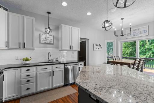 Center island with breakfast bar seating, granite countertops, tile backsplash, and a closet pantry.