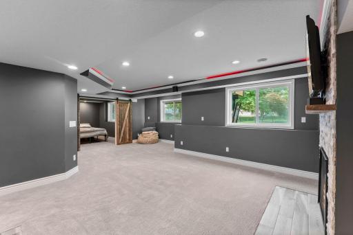 The spacious family room features carpeting and decorative framing with ambient lighting.