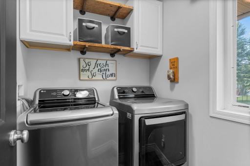 The main level also includes a functional mudroom with garage access, laundry room with LG washer and dryer, cabinetry and shelving for additional storage.