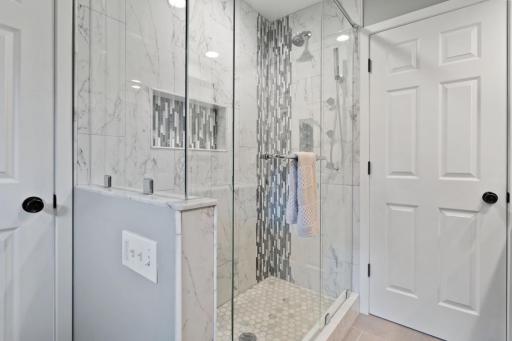 Bright, updated bathroom with a glass door walk-in shower with beautifully tiled surround and a recessed shampoo niche. Clean, modern finishes for a spa-like feel with a fresh, polished look. Both baths have Ultraviolet germicidal lights!