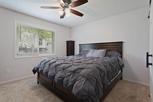 Spacious primary bedroom with room for a king bed, newer ceiling fan with remote, and beautiful backyard views. Updated white faux wood blinds throughout the home (2022-2023) and a clean, modern touch and complete this bright, comfortable retreat.
