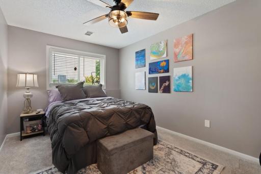 The other lower level bedroom offers fresh updates including new carpet and paint, plus a ceiling fan with remote for added comfort.