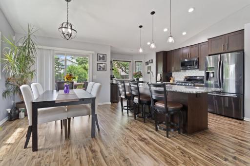This gorgeous kitchen was remodeled in 2017 with new mocha cabinetry, granite countertops, large island with convenient USB/electric outlets, modern slate appliances, herringbone backsplash, recessed lighting, updated plumbing, and an open layout.