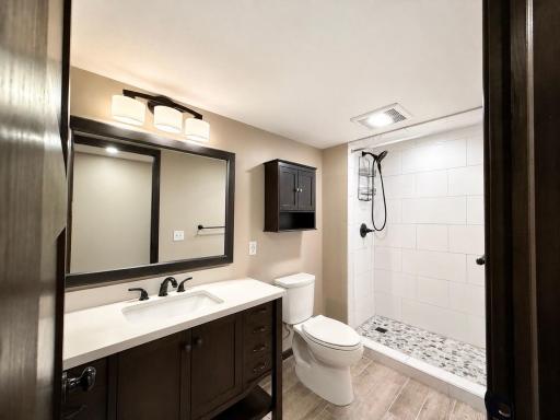 Modern bathroom with tile floors and walk-in tile shower in the basement