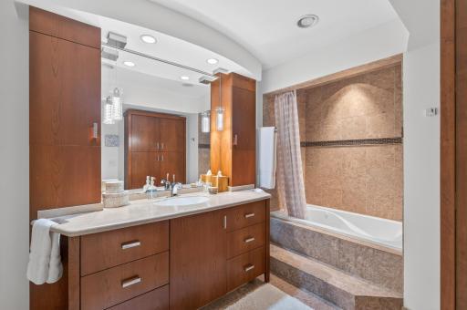 Huge custom bath with travertine tile and loads of storage
