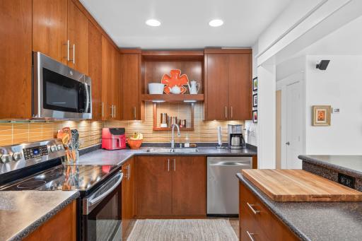Glass tiled backsplash, undercabinet lighting and hidden electrical outlets.