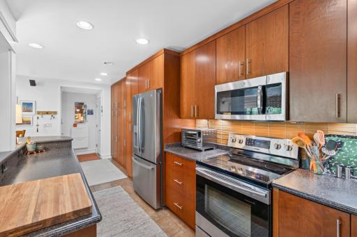 Pantry cabinet to the left of frig includes a roll-out appliance shell with outlets and drawers