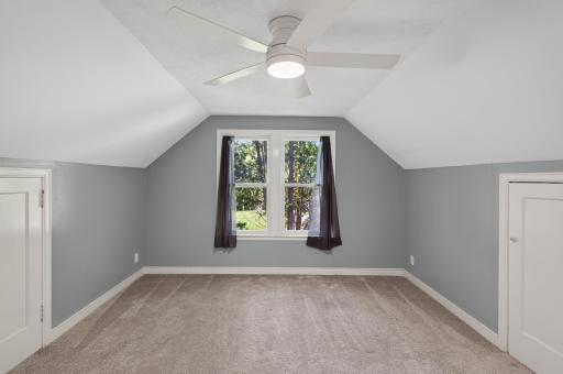 This bedroom has a remote-operated ceiling fan and two knee-wall storage areas. It also has a large closet...
