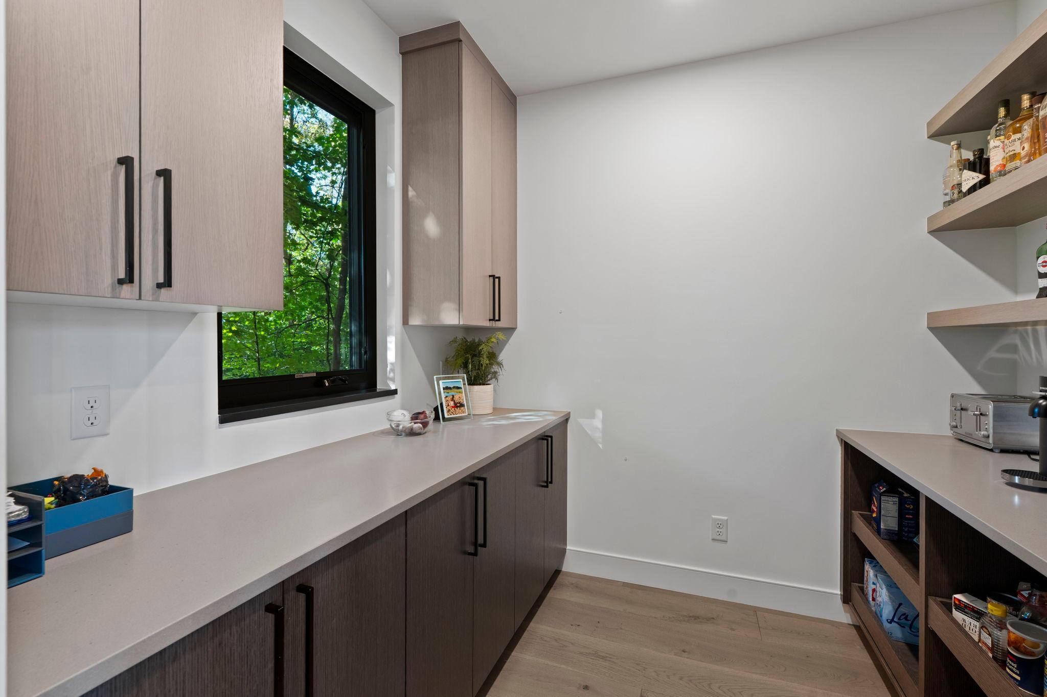 Contemporary high-end kitchen with adjoining, walk-in custom pantry.