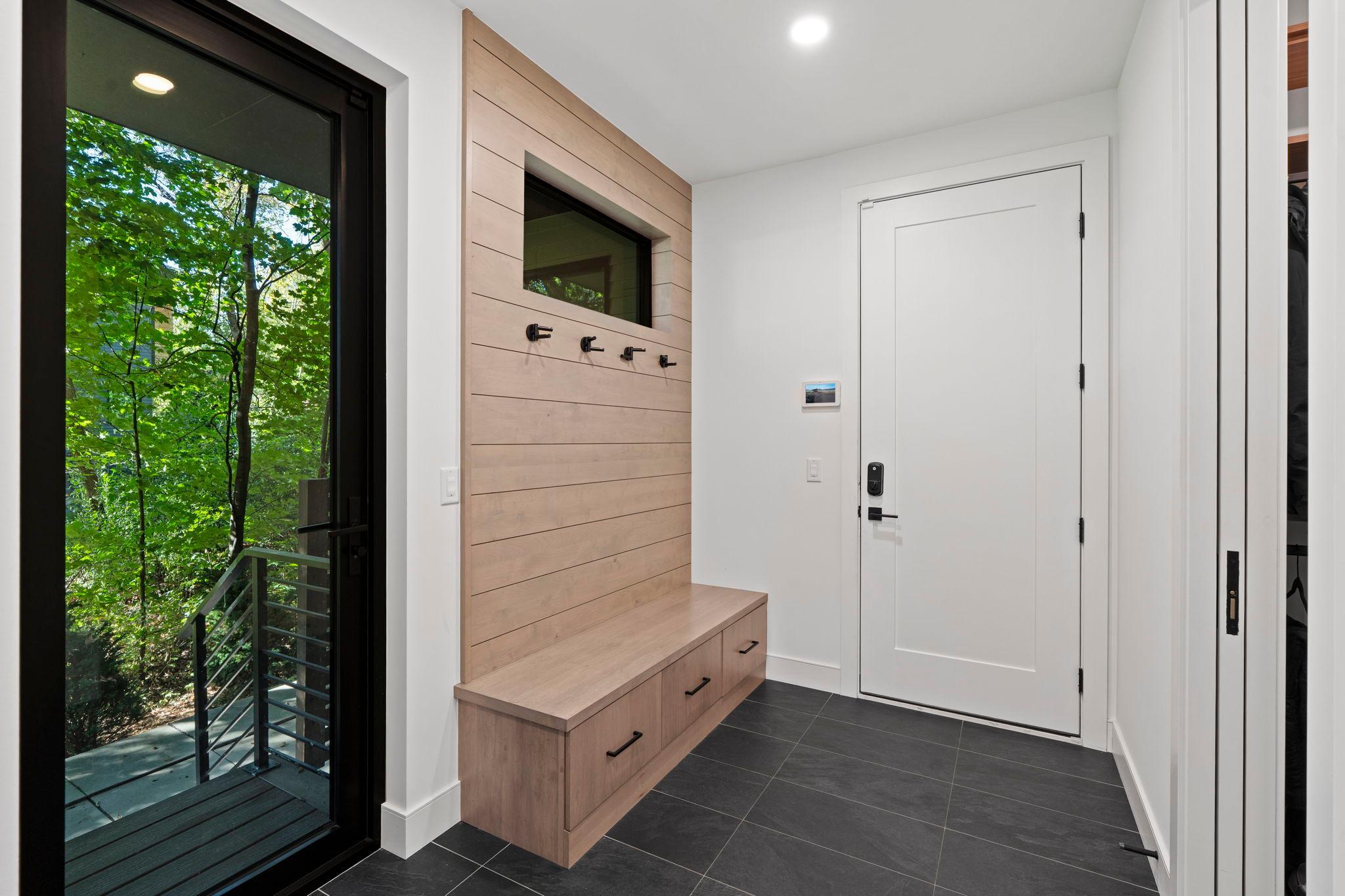 Stylish mudroom featuring designer tile and a charming shiplap bench—where function meets flair.