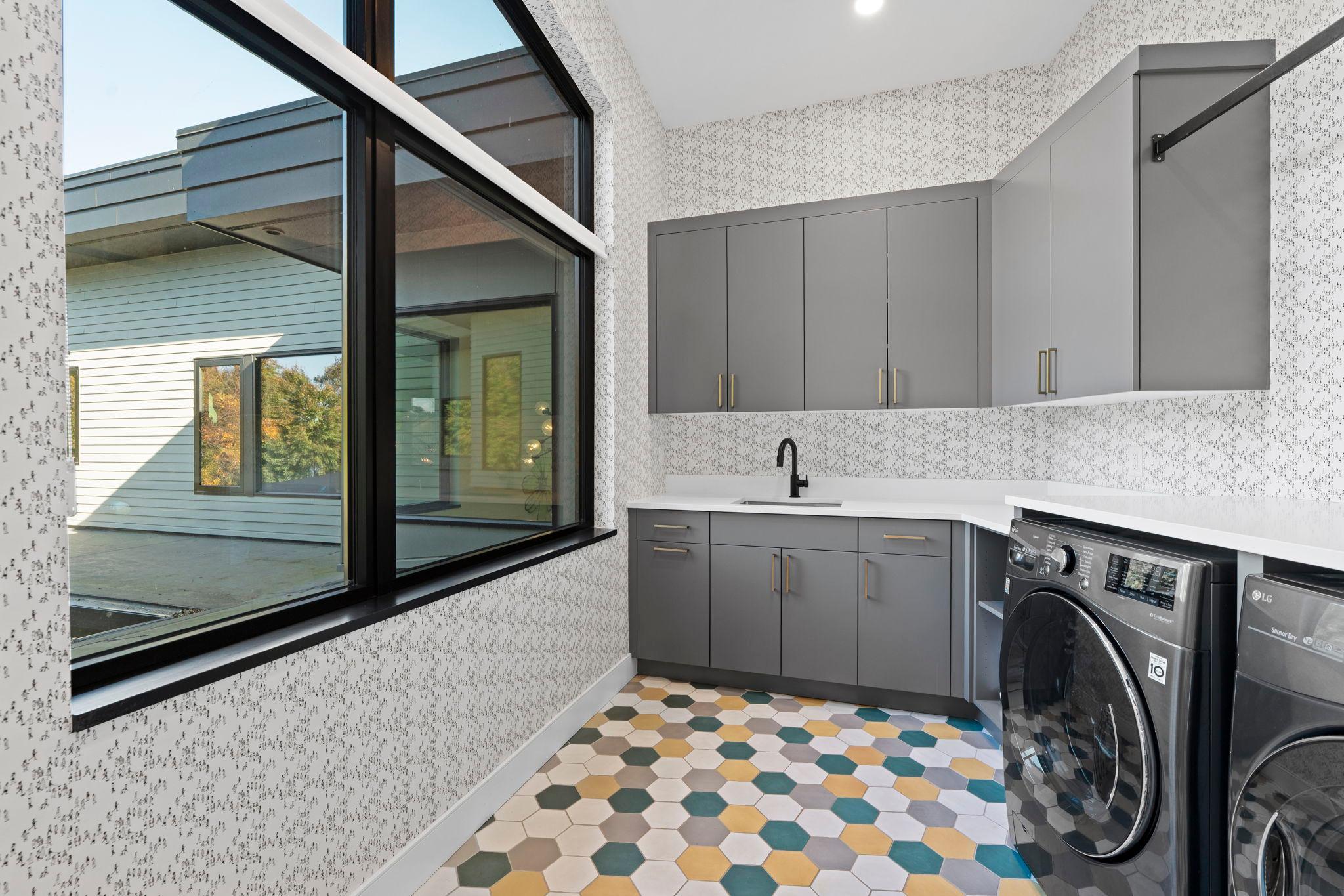 Chic upper-level laundry with bold color accents, custom cabinetry, and thoughtful design.