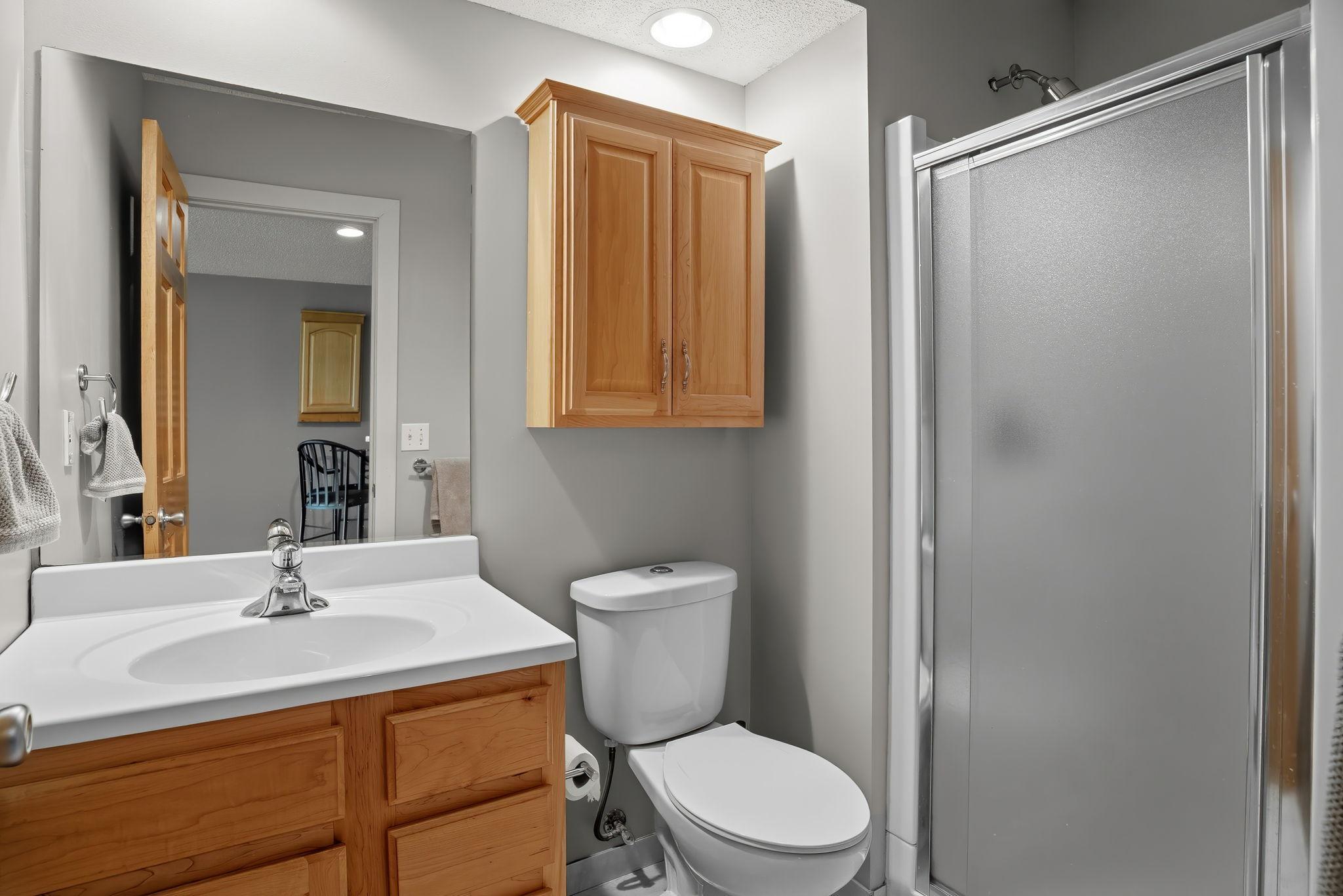 A 3/4 bath and massive storage room with cabinetry & hobby bench completes the space.