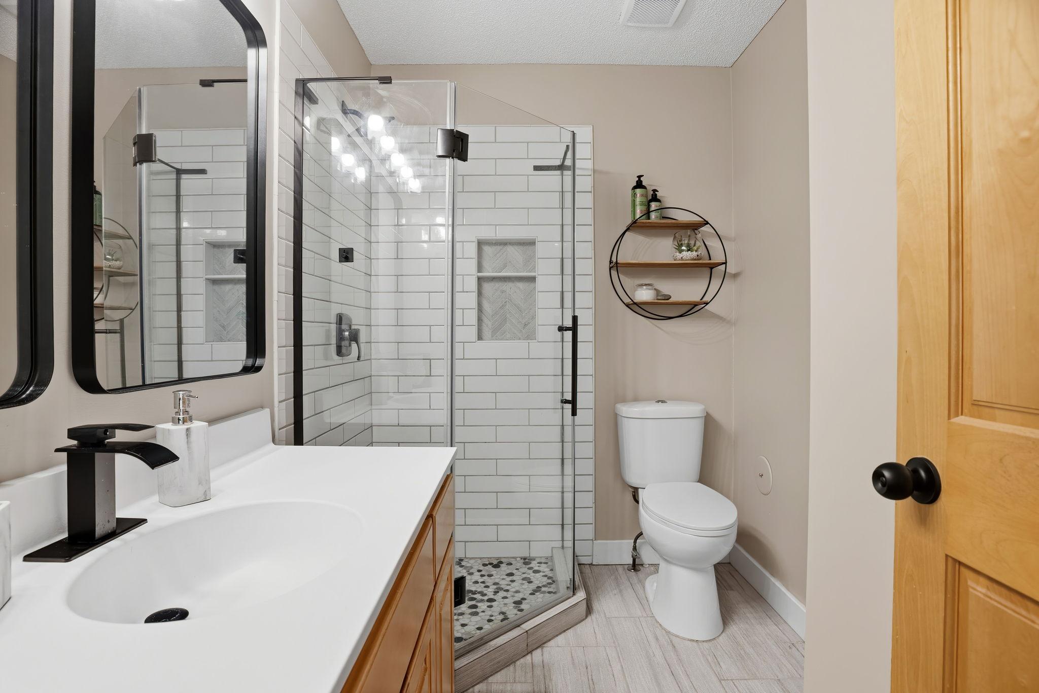 Primary bathroom newly refreshed with tile flooring & shower.