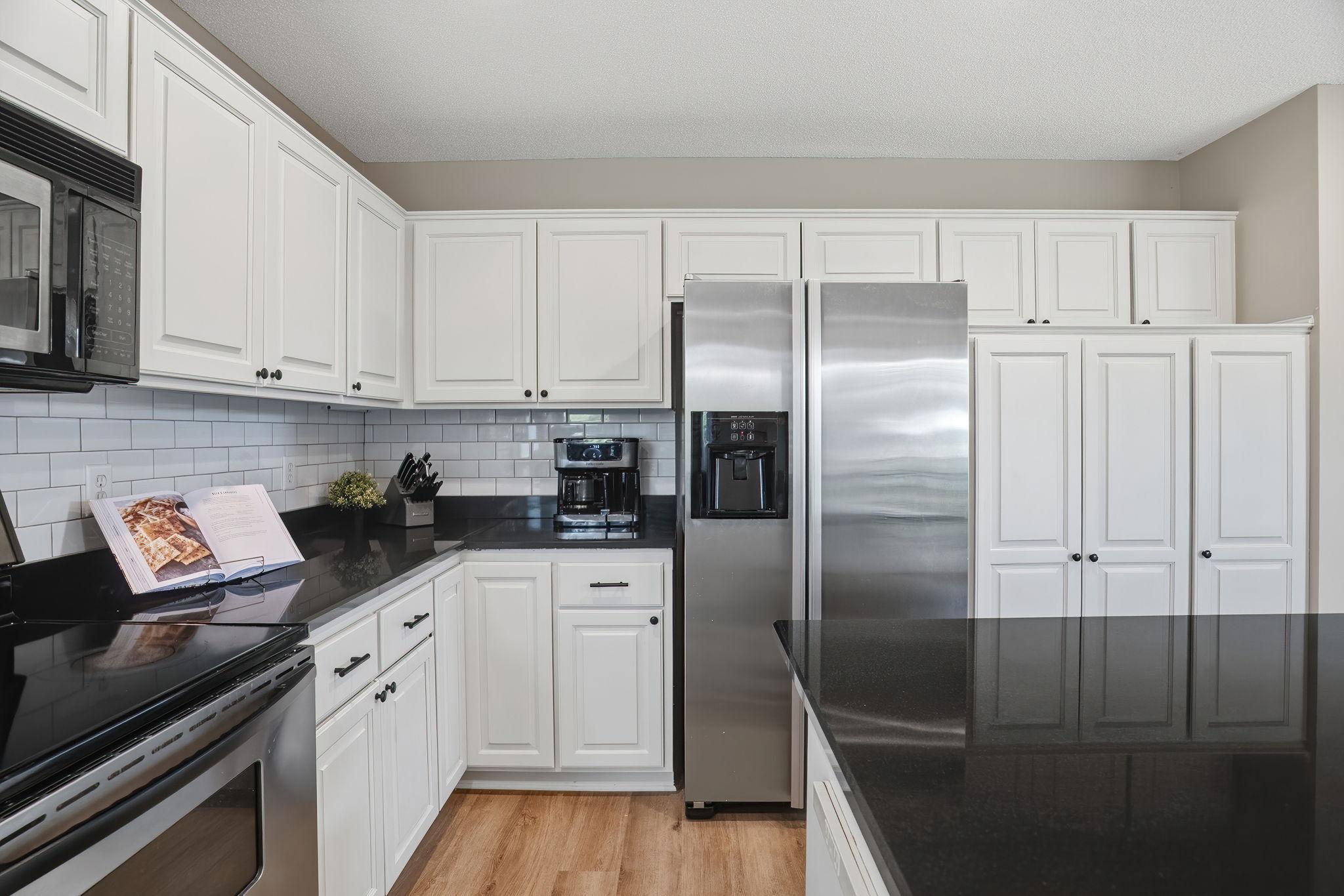 Stainless steel appliances and adjacent pantry completes the updated kitchen.