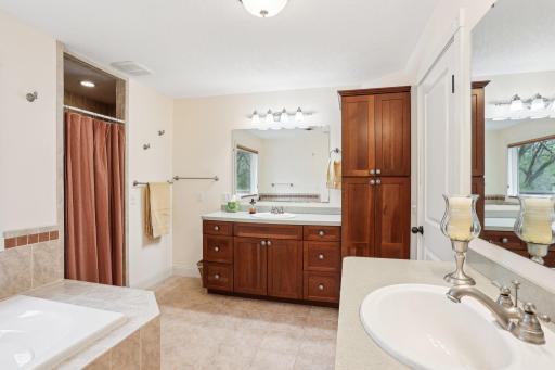 Primary bath includes dual sinks/vanities, separate shower and soaking tub plus adjacent walk-in closet.