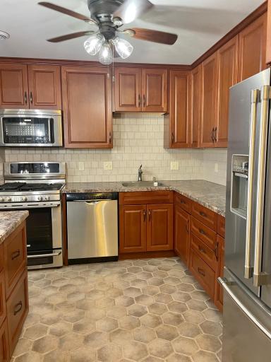 Beautifully updated kitchen with custom cherry wood cabinet and stainless steel appliances.