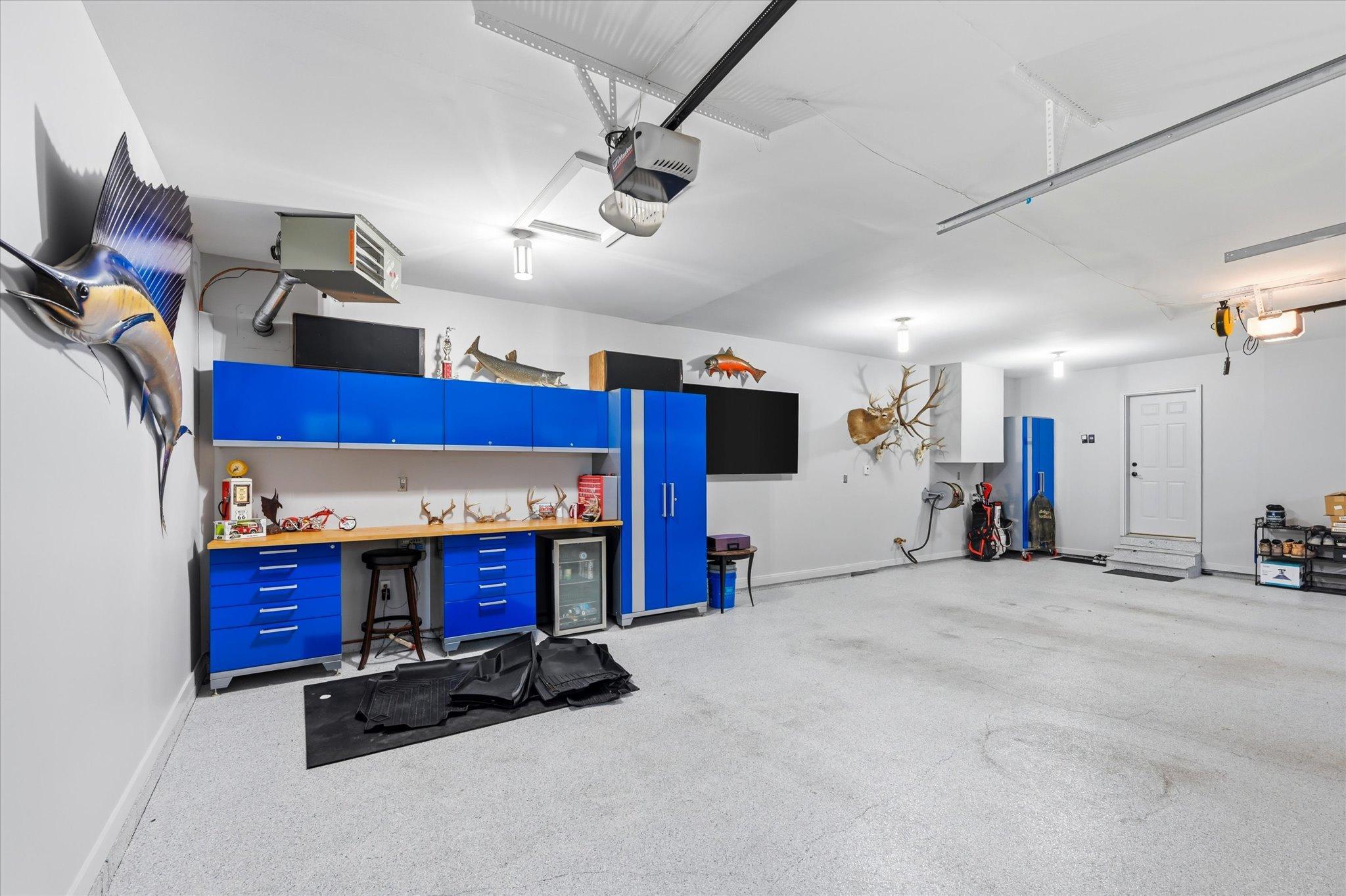 Attached garage with plenty of storage cabinets.