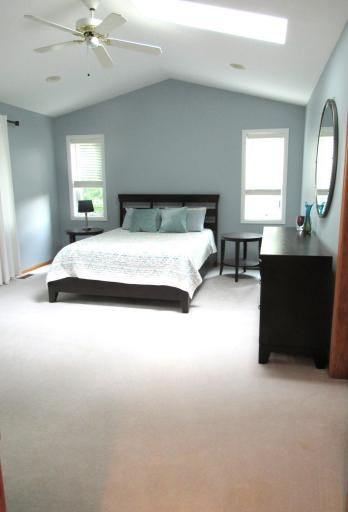 Huge primary bedroom with fresh paint, sitting area, updated window treatments and natural lighting.