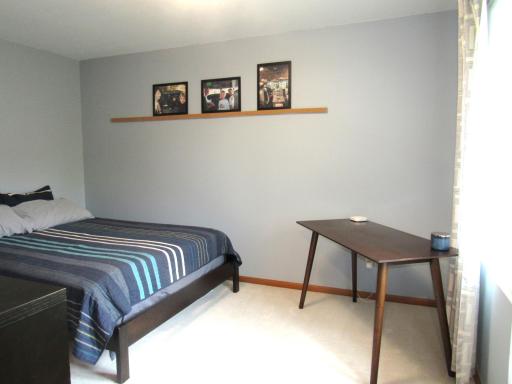 Upper level bedroom with a walk-in closet and ceiling lighting.