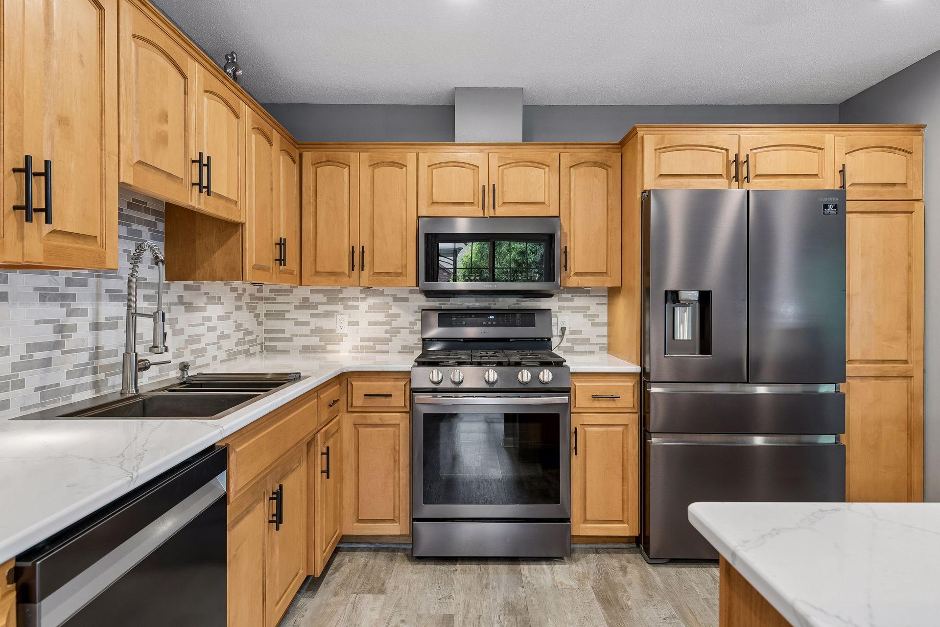 Updated Kitchen with Quartz countertops, tile Backsplash and black Stainless Steel appliances