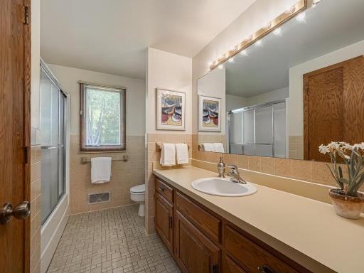 Upper level full bath with ceramic tiled floor and tub/shower combination with sliding doors.