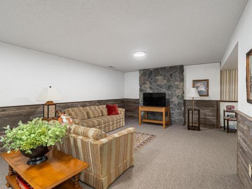 Lower level family room with rock faced background wall . Sorry there was never a fireplace added in this rock wall but perfect spot to install gas fireplace at a later date!