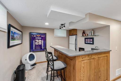 Your favorite room in the house might be downstairs. This beautifully finished lower level features a cozy gas fireplace, custom entertainment wall, wet bar with beverage storage.