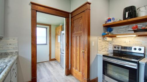 Range in kitchen on the right. Closed door opens to stairway leading to the lower level family room, third bedroom, 1/2 bath, laundry and utility room.
