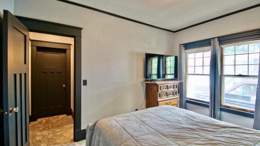 Interior view of primary bedroom. Second bedroom is the closed door straight ahead. Full bathroom is to the right in-between both bedrooms.