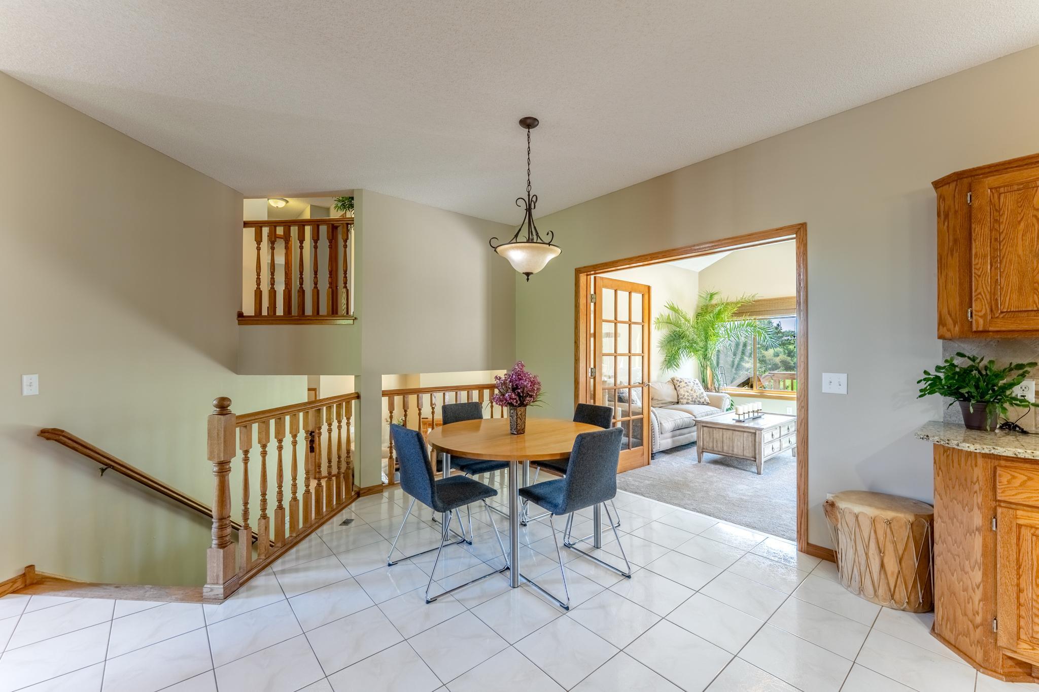 Through French doors, the kitchen and breakfast area flow seamlessly into the bright sunroom beyond.