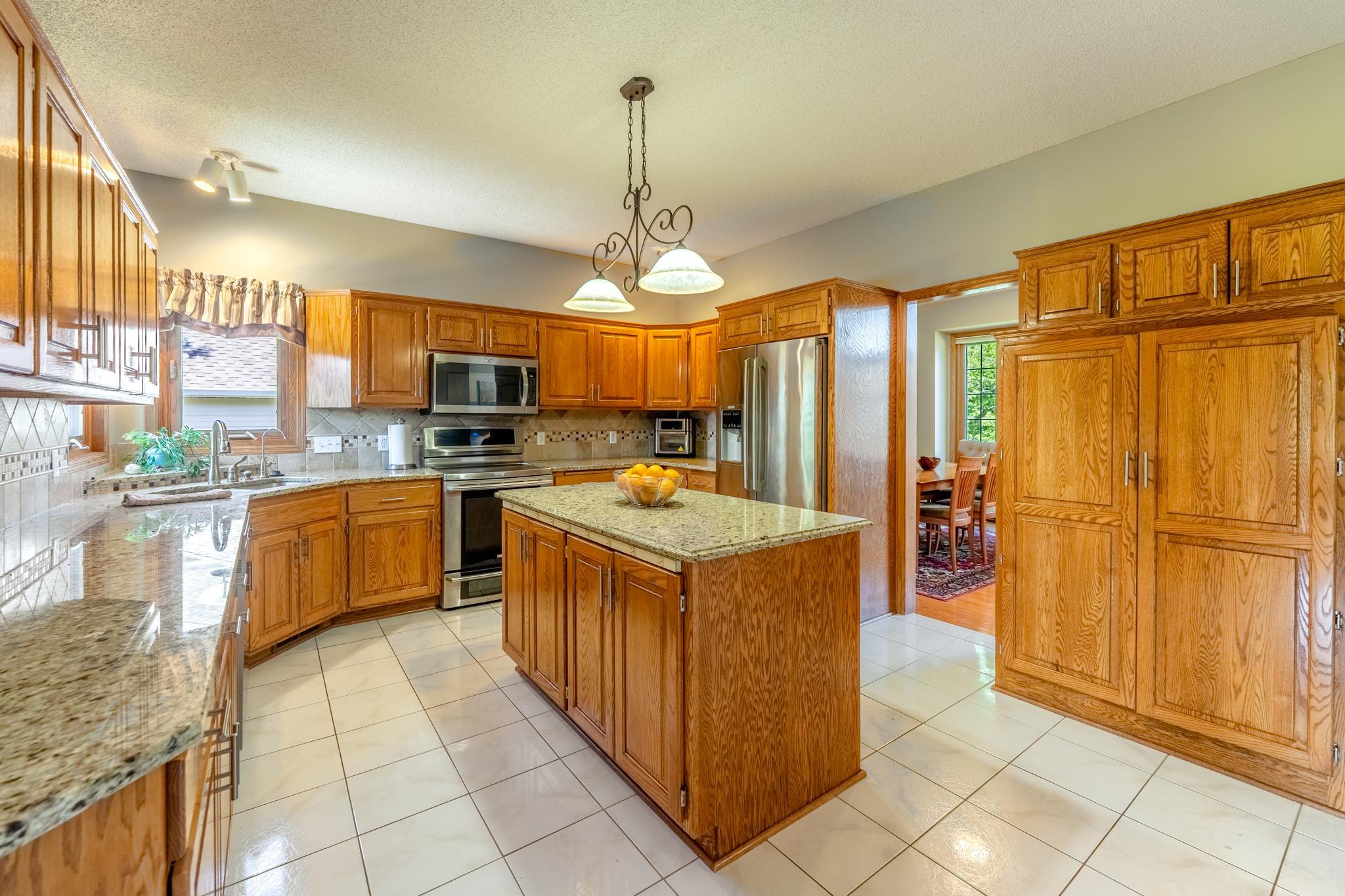 Roomy kitchen with an abundance of cupboards and a kitchen island for extra seating or space for meal prep.
