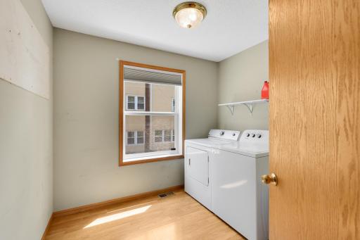 Dedicated main-level laundry room with extra storage space.