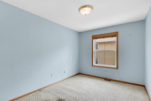 Bright third bedroom with a large window and closet.