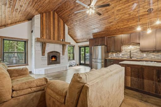 Ceiling high wood burning fireplace centers the back wall.
