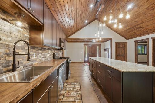 Custom cabinets with ledgestone backsplash and butcher block countertops.