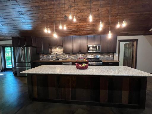 The large kitchen island features granite countertop and lots of storage below.