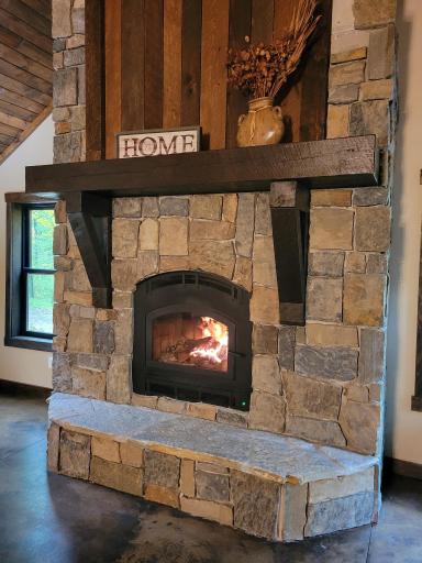 Ceiling high wood burning fireplace centers the back wall with stone and stained pine accents. Almost finished!