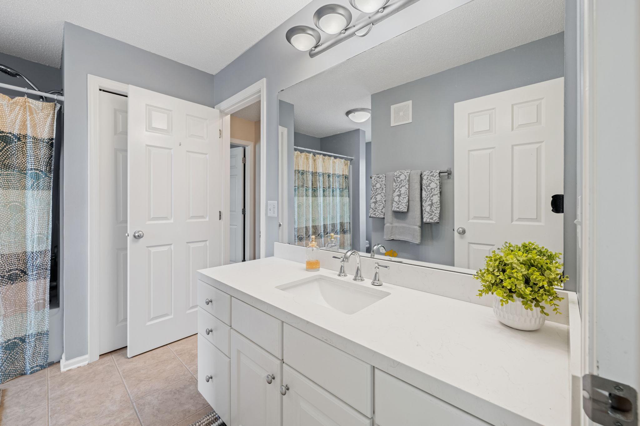 Upper level full bath with oversized vanity & linen storage.