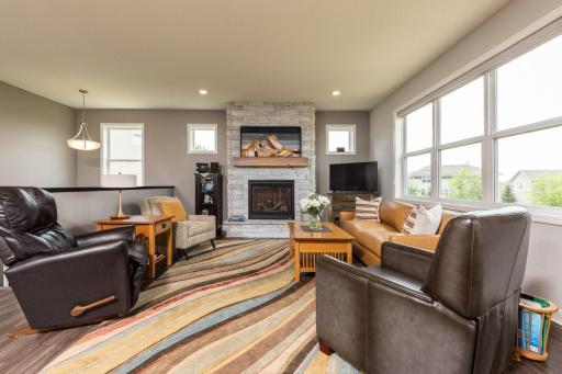 Bathed in natural light, the living room is anchored by the floor to ceiling stone fireplace