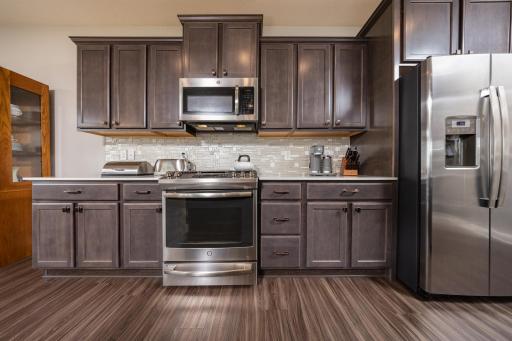 Custom cabinetry, quartz countertops and glass tile backsplash