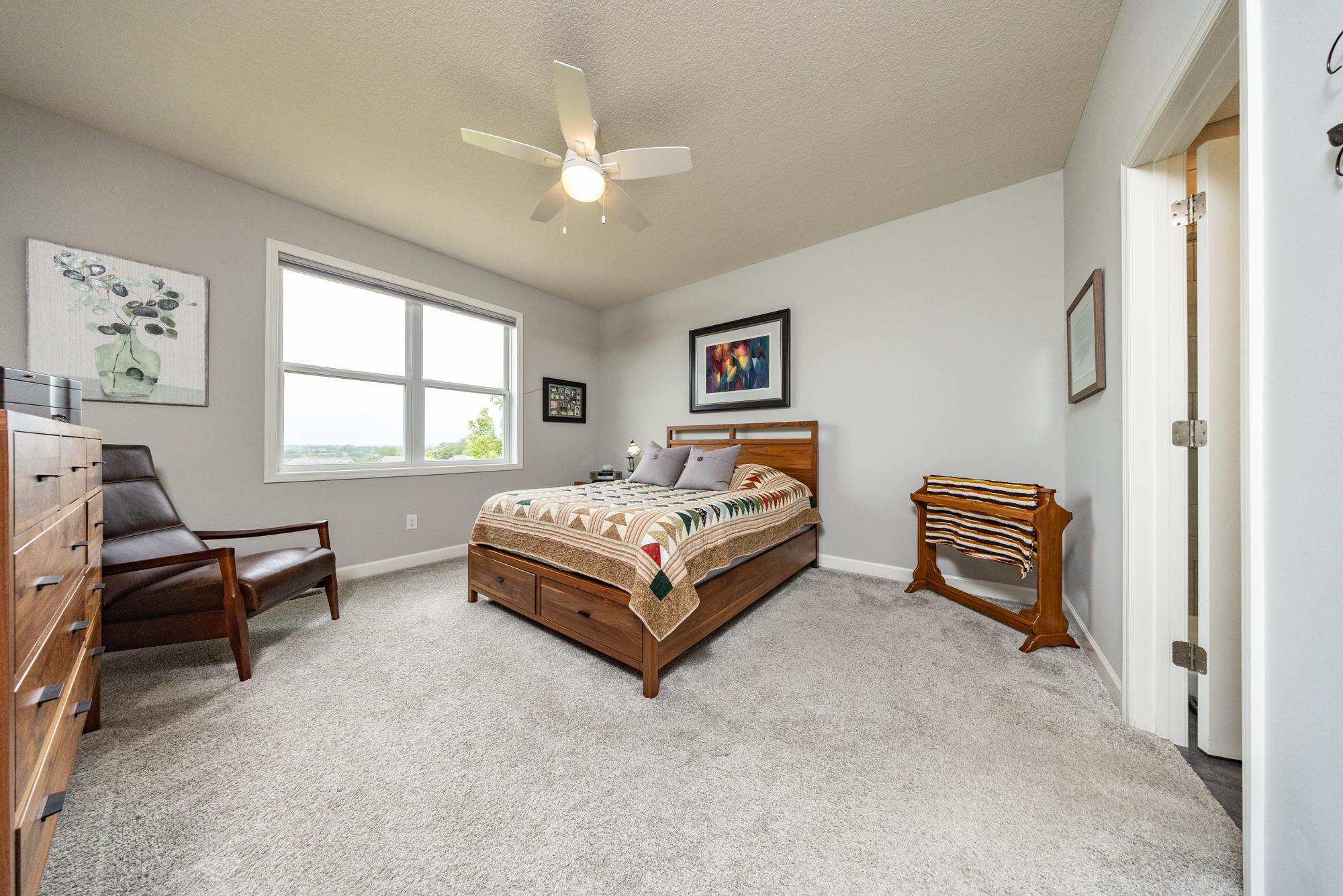 The main-level primary suite offers a peaceful retreat overlooking the backyard