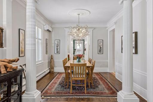 Formal dining room with pillars and high windows, note plantation shutters throughout
