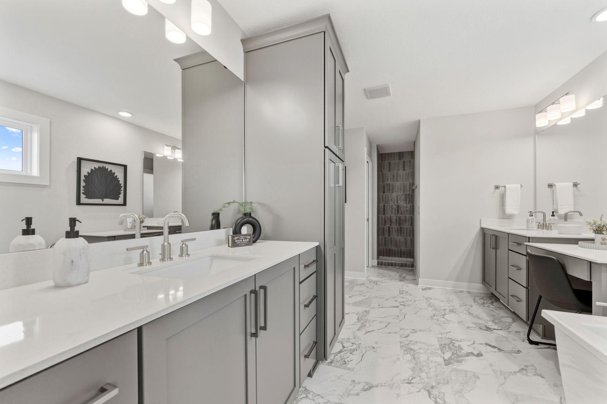 Primary bedroom ensuite with separate dual vanities, fully tiled walk-in shower, freestanding soaker tub and his/hers closet sides