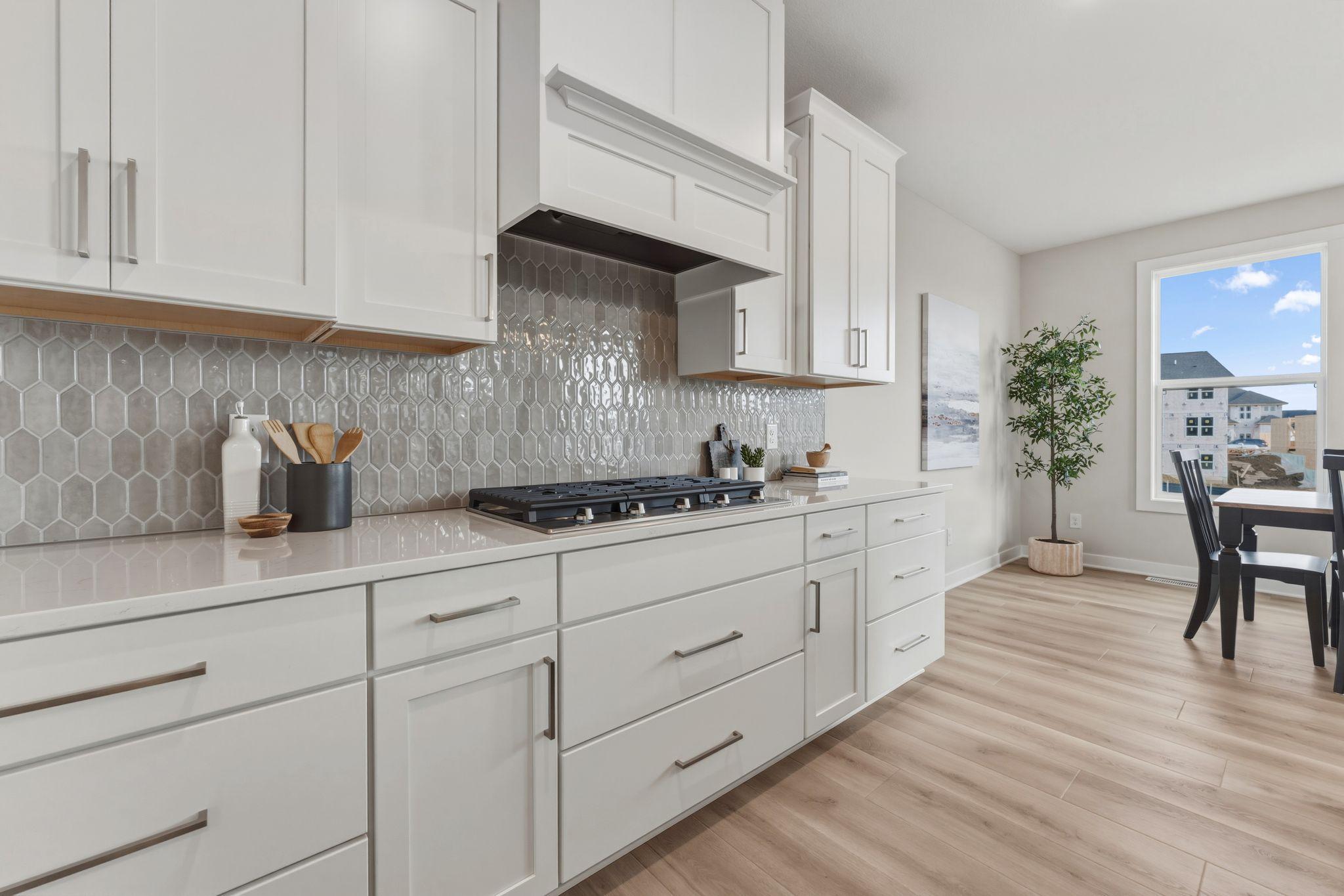 Gourmet kitchen with wall oven and microwave, gas range and built-in hood vent with upgraded stainless steel appliances