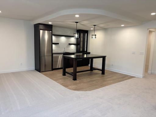 Dropped ceiling and plank flooring defines the bar area