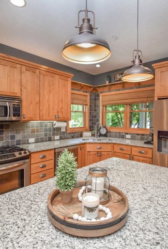 Well lit kitchen with newer stainless appliances