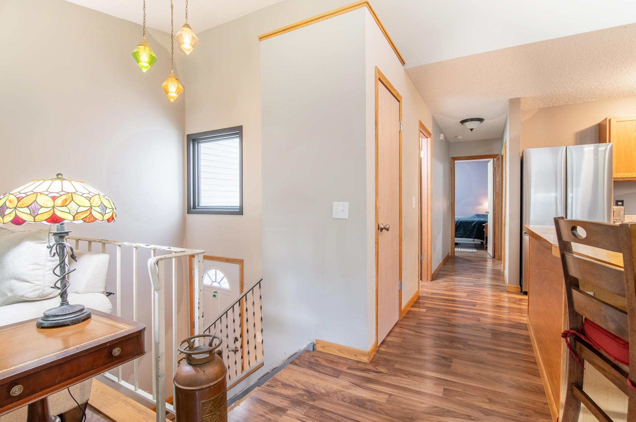 A striking light fixture frames the front entry. Seller is willing to have carpet installed prior to closing for stairs seen at left.