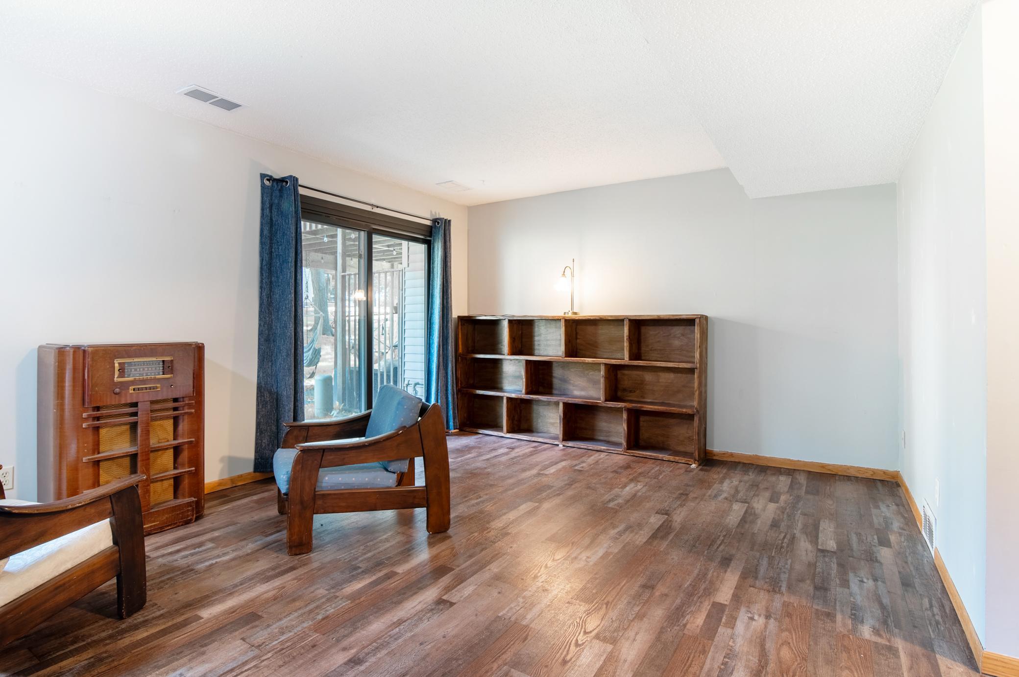 The cozy lower level family area steps out to grass and trees in the shade of mature oaks.
