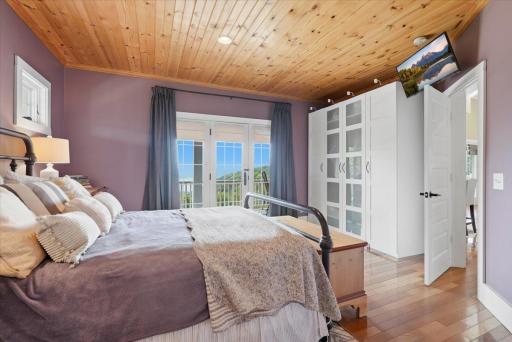 Main floor primary bedroom with large closet and bathroom ensuite. Beautiful doors open to wrap around porch and offer views of the lake