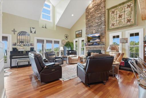 Stunning main living room with vaulted ceilings, custom stone wood burning fireplace and views of Lake Pepin